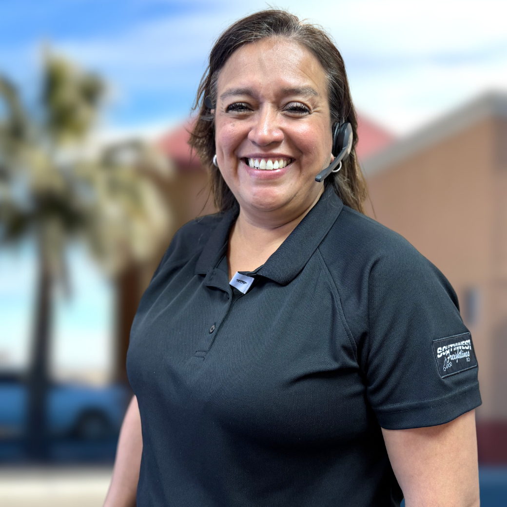 Dispatch team member smiles at the camera in front of the headquarters building at Southwest Freightlines